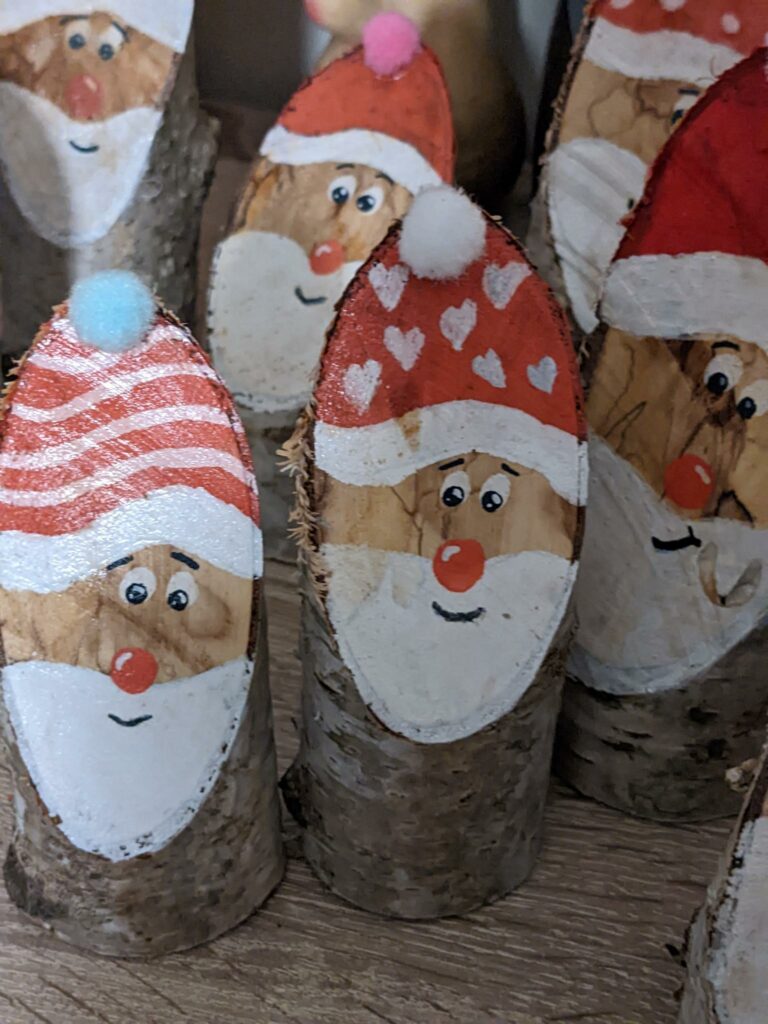 Weihnachtsmänner aus Baumstämmen.